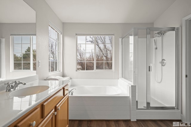 bathroom featuring hardwood / wood-style flooring, vanity, and separate shower and tub