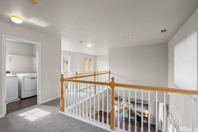 corridor with washer and clothes dryer and carpet