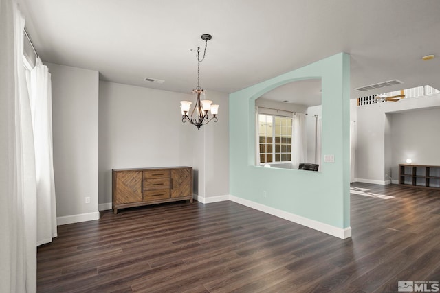 spare room with dark hardwood / wood-style flooring and a chandelier