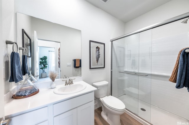 bathroom featuring hardwood / wood-style floors, vanity, toilet, and walk in shower