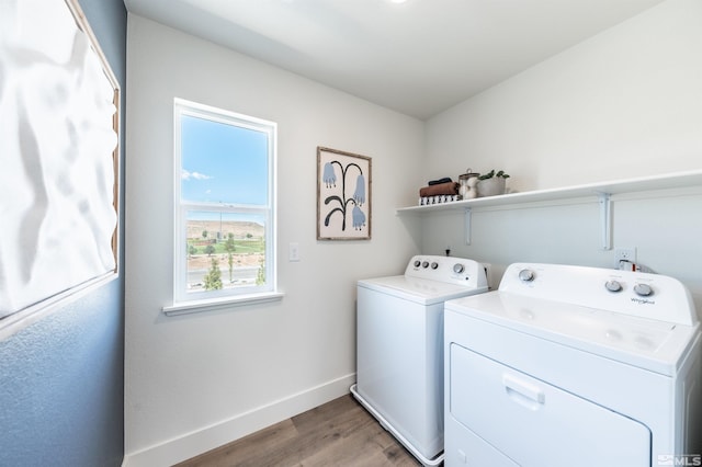 clothes washing area with light hardwood / wood-style floors and washer and dryer