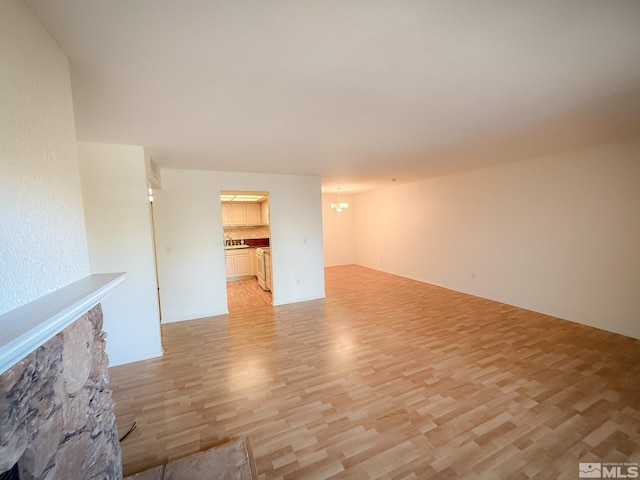 unfurnished living room featuring light hardwood / wood-style flooring and a notable chandelier