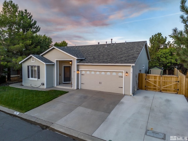 ranch-style home with a garage and a yard