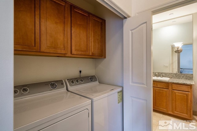 washroom with sink, cabinets, and washing machine and clothes dryer