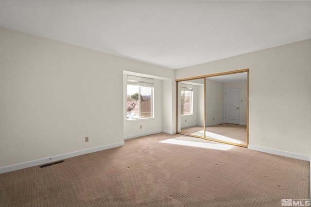 unfurnished bedroom featuring a closet and light carpet