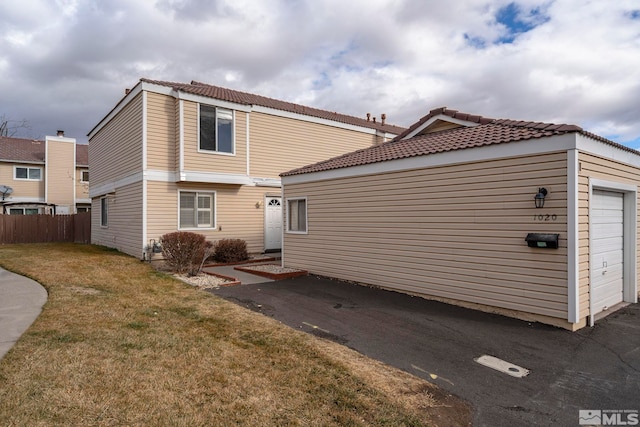 rear view of house with a garage and a lawn