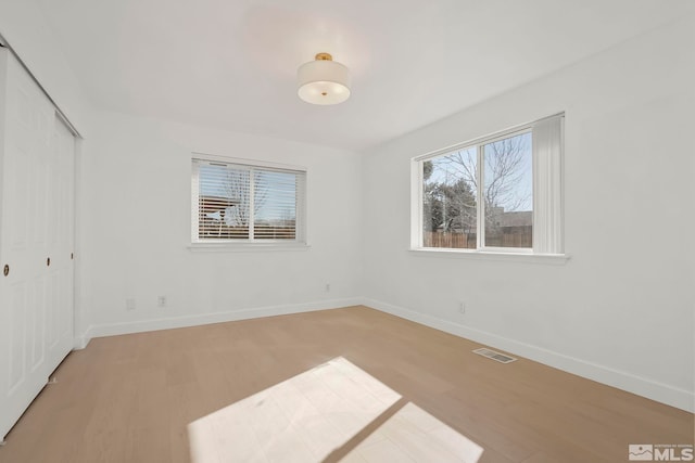 unfurnished bedroom featuring light hardwood / wood-style floors and a closet