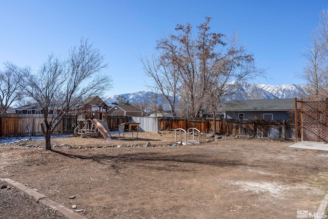 view of yard with a playground and a mountain view