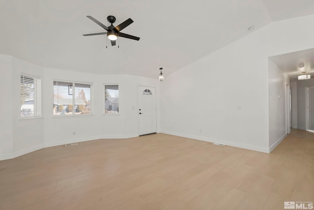 empty room with lofted ceiling, light hardwood / wood-style flooring, and ceiling fan