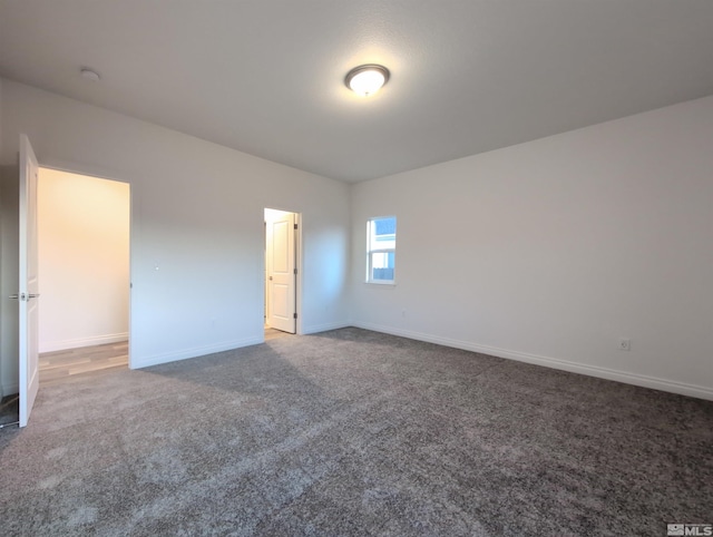 unfurnished bedroom with dark colored carpet