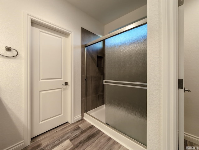 bathroom with hardwood / wood-style flooring and walk in shower