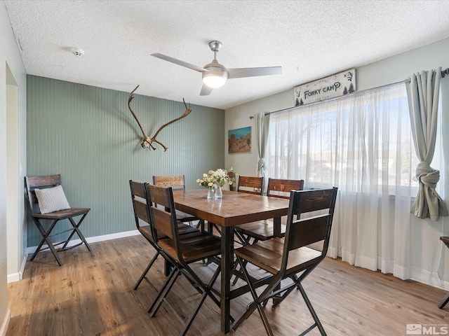 dining room featuring ceiling fan, a textured ceiling, and light wood-type flooring