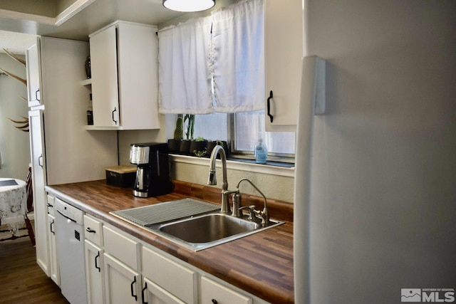 kitchen with refrigerator, white cabinetry, sink, butcher block counters, and white dishwasher