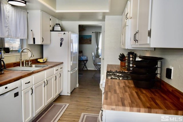 kitchen with white cabinetry, sink, white appliances, and wood counters