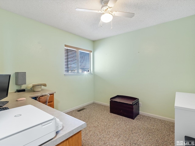 carpeted office featuring ceiling fan and a textured ceiling