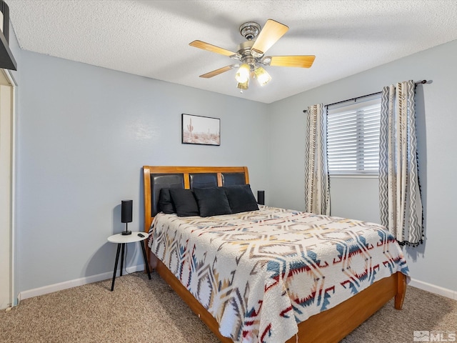 bedroom with ceiling fan, carpet floors, and a textured ceiling