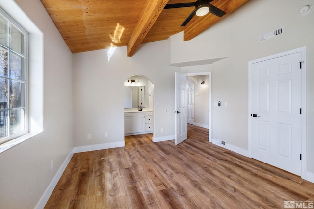 unfurnished bedroom with vaulted ceiling with beams, wooden ceiling, light hardwood / wood-style floors, and ensuite bathroom