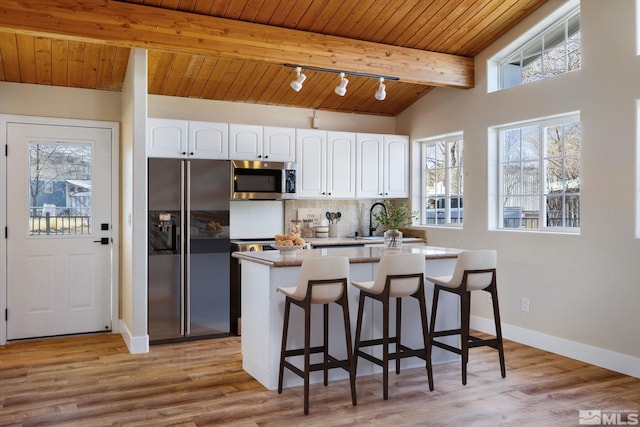 kitchen featuring a breakfast bar area, white cabinets, decorative backsplash, wood ceiling, and black refrigerator with ice dispenser