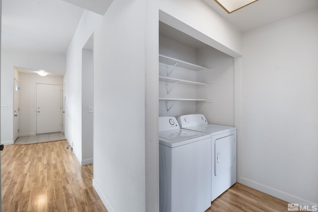 washroom with independent washer and dryer and light wood-type flooring