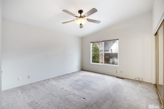 unfurnished bedroom featuring ceiling fan, a closet, lofted ceiling, and light carpet