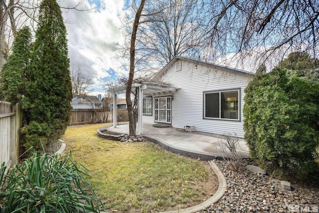 back of property with a lawn, a patio area, and a pergola