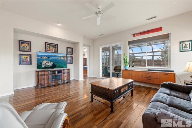 living room featuring ceiling fan and dark hardwood / wood-style flooring