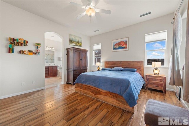 bedroom with ceiling fan, connected bathroom, and light wood-type flooring