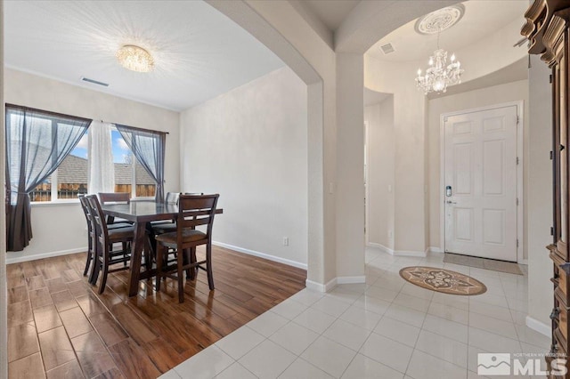 dining space featuring hardwood / wood-style flooring and a chandelier