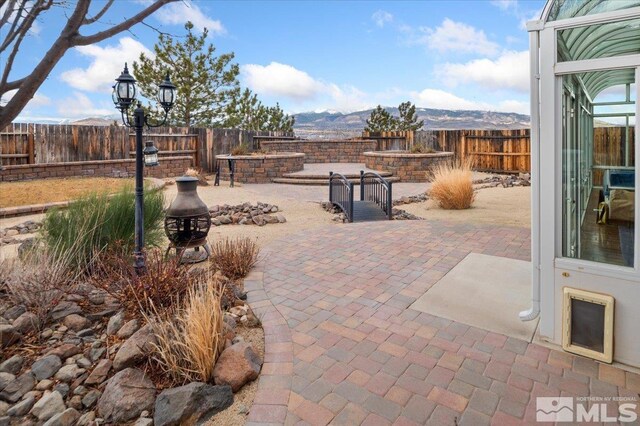 view of patio with a mountain view and a fire pit