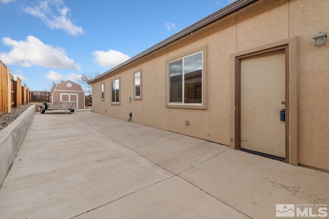 view of side of home with a patio and a storage unit