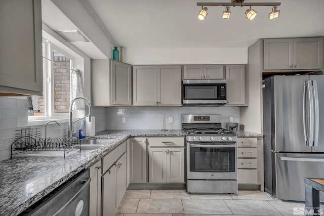 kitchen featuring light stone countertops, backsplash, and stainless steel appliances