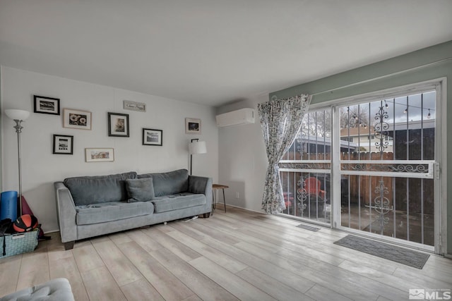 living room featuring light wood-type flooring and a wall unit AC