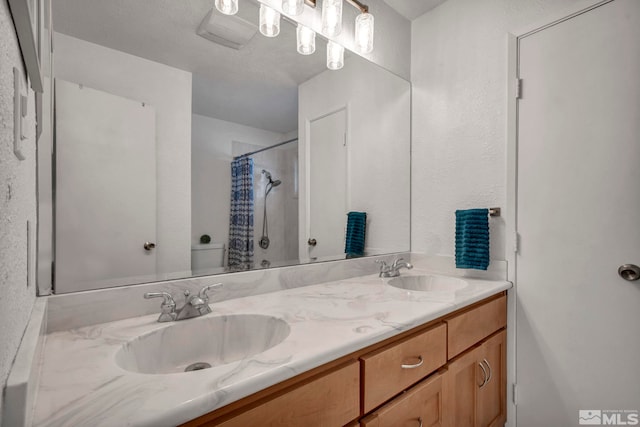 bathroom featuring walk in shower, vanity, and toilet