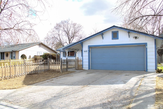 view of front facade with driveway, a fenced front yard, and an attached garage