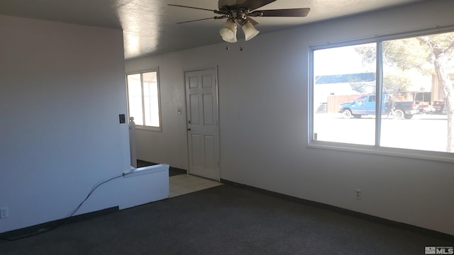 spare room featuring plenty of natural light and ceiling fan