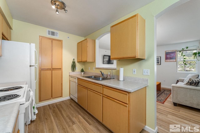 kitchen with sink, white appliances, light wood-type flooring, and light brown cabinets