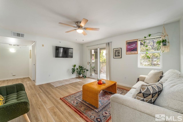 living room featuring light hardwood / wood-style flooring and ceiling fan