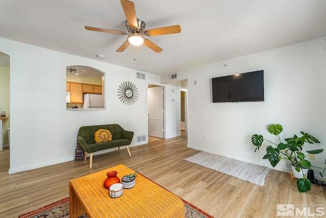 living room featuring hardwood / wood-style floors and ceiling fan