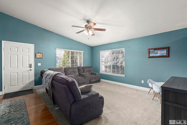 living room featuring a textured ceiling, vaulted ceiling, and ceiling fan