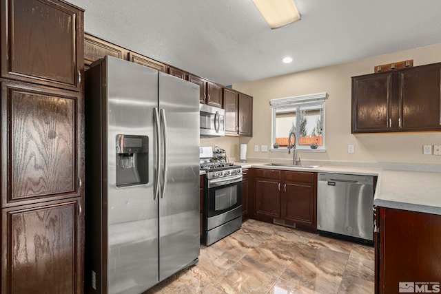 kitchen with dark brown cabinetry, stainless steel appliances, and sink