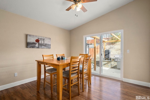 dining space with ceiling fan, dark hardwood / wood-style flooring, and vaulted ceiling