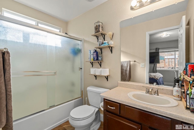 full bathroom featuring vanity, toilet, and combined bath / shower with glass door