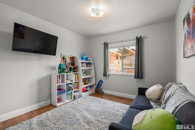 rec room with wood-type flooring and a textured ceiling