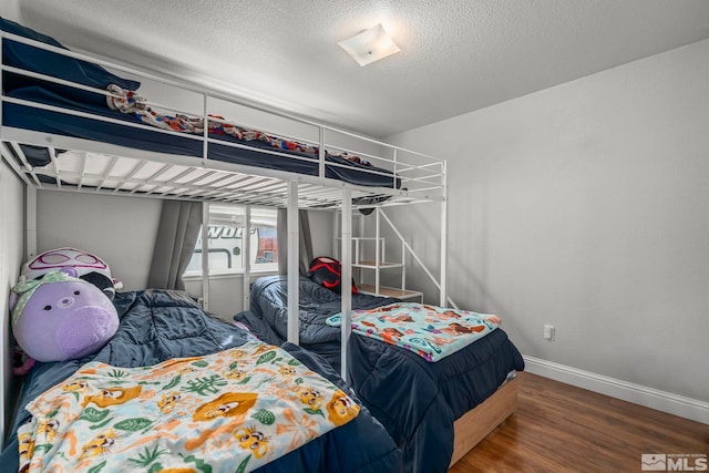 bedroom with wood-type flooring and a textured ceiling