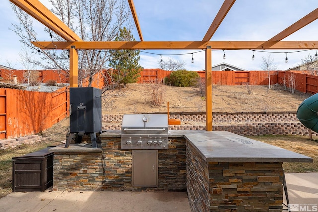 view of patio / terrace with area for grilling, a pergola, and an outdoor kitchen