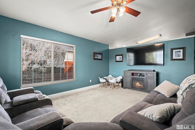 carpeted living room featuring ceiling fan and a textured ceiling