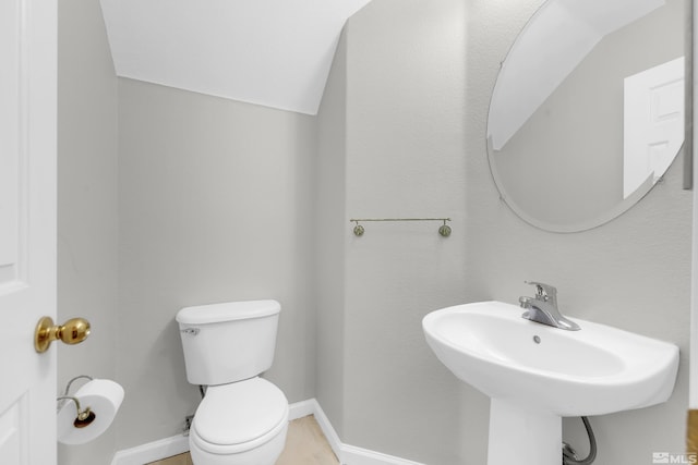 bathroom featuring lofted ceiling, sink, and toilet