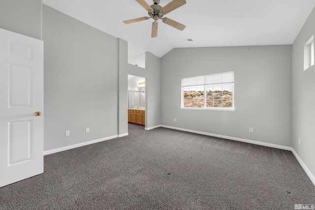 unfurnished bedroom with lofted ceiling, ensuite bathroom, ceiling fan, and dark colored carpet