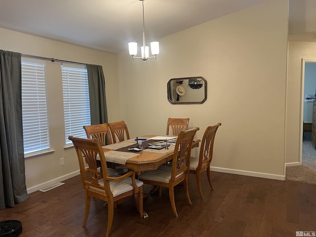 dining space with dark hardwood / wood-style floors and a notable chandelier