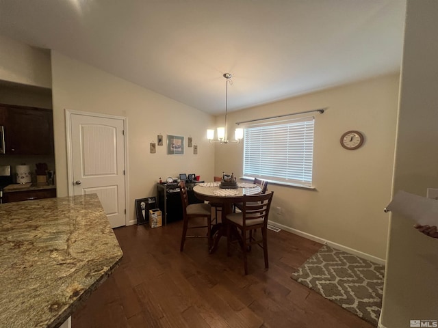 dining area featuring dark wood-type flooring, vaulted ceiling, and a notable chandelier